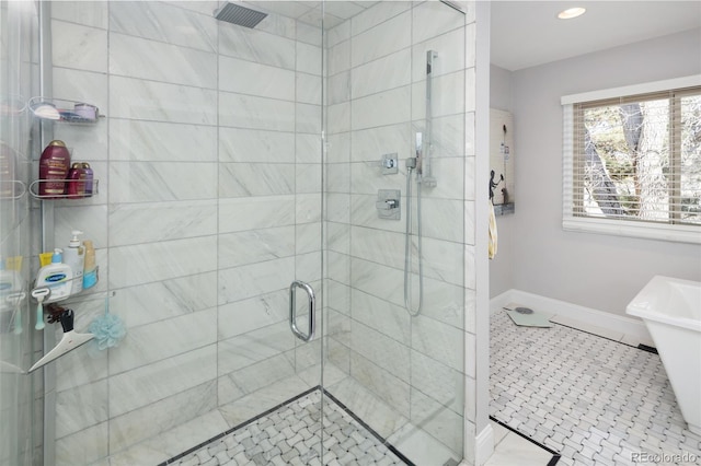 full bath featuring tile patterned floors, baseboards, and a tile shower