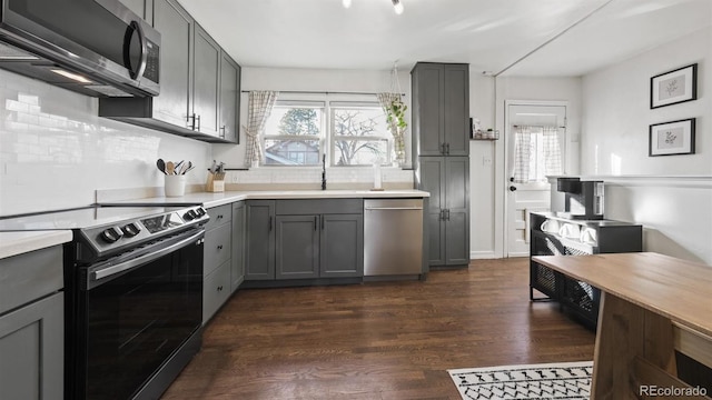 kitchen featuring gray cabinetry, stainless steel appliances, plenty of natural light, and dark hardwood / wood-style floors