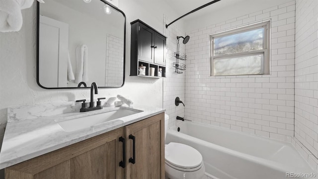 full bathroom with toilet, vanity, and tiled shower / bath