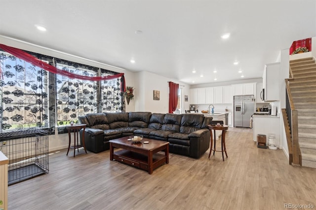 living room featuring light wood-style floors, stairs, and recessed lighting