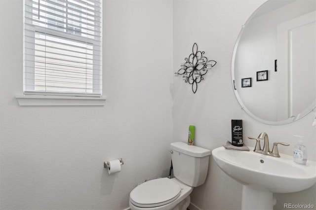 half bathroom featuring toilet and a sink