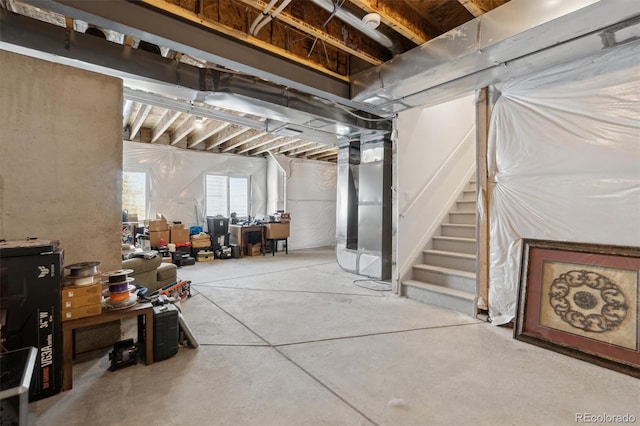 basement featuring heating unit and stairs