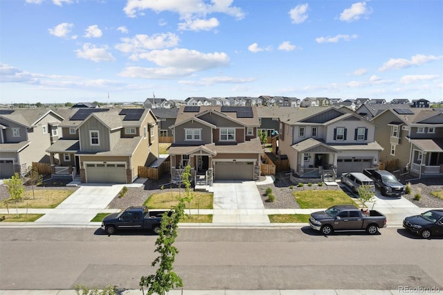view of front of house featuring a residential view, concrete driveway, an attached garage, and fence