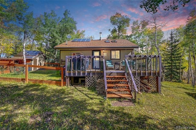 205 Ohler Ct, Jefferson, CO 80456 - rear view of house with solar panels, a deck, stairs, and a lawn