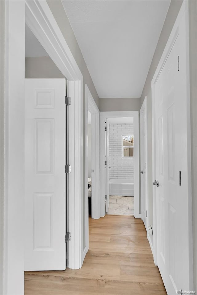 hallway with light hardwood / wood-style floors