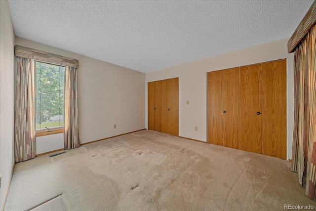 31 Irene Ct, Broomfield, CO 80020 - unfurnished bedroom with two closets, carpet floors, and a textured ceiling