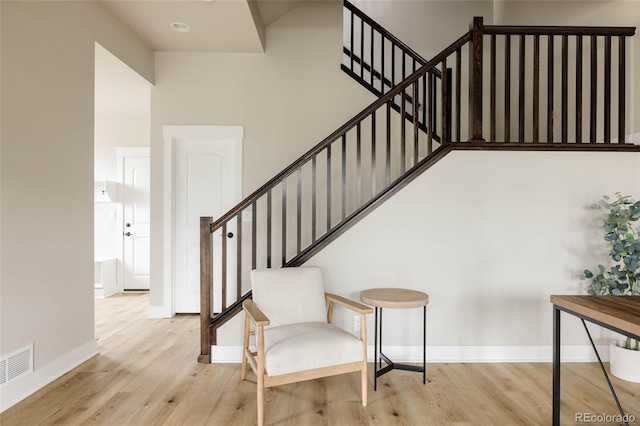 stairway with wood finished floors and baseboards