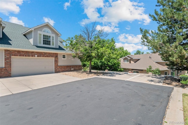 12502 E Harvard Cir, Aurora, CO 80014 - view of front of property featuring brick siding, a shingled roof, and driveway