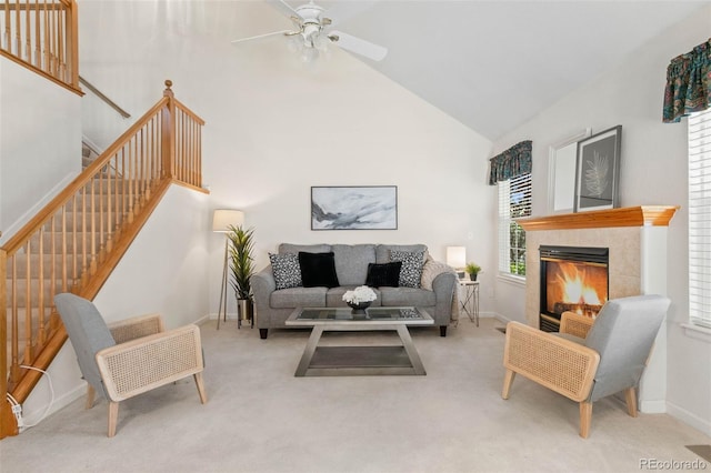 12502 E Harvard Cir, Aurora, CO 80014 - living area with stairs, carpet, a ceiling fan, high vaulted ceiling, and a tile fireplace