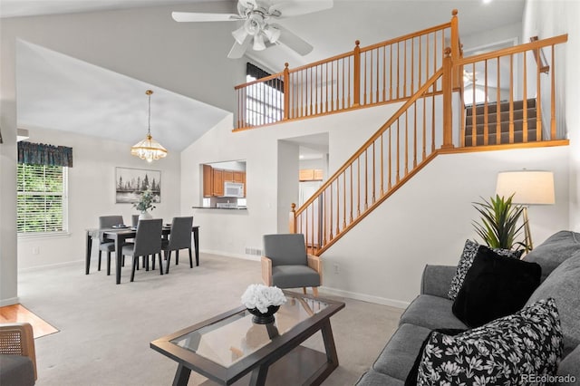 12502 E Harvard Cir, Aurora, CO 80014 - living room featuring stairway, carpet flooring, ceiling fan, high vaulted ceiling, and a chandelier
