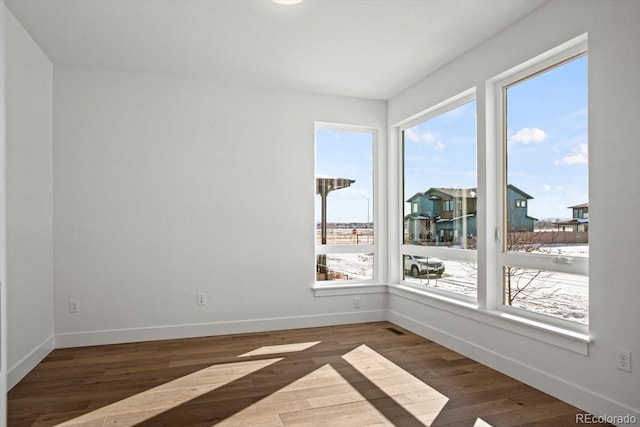 empty room with dark hardwood / wood-style flooring