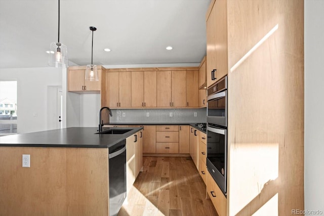 kitchen with an island with sink, sink, and light brown cabinets