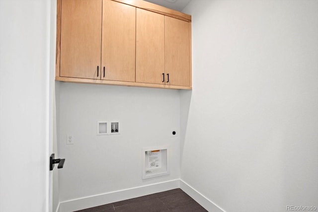 washroom featuring cabinets, washer hookup, dark tile patterned floors, and electric dryer hookup