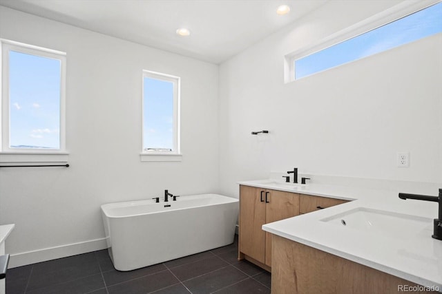 bathroom with tile patterned flooring, vanity, and a bath