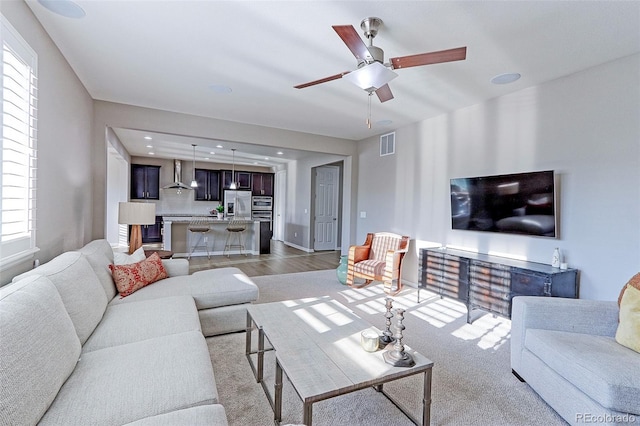 living room with ceiling fan and light hardwood / wood-style flooring