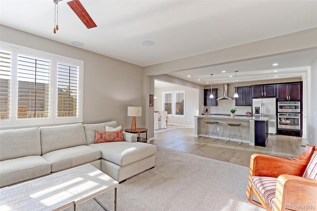 living room featuring light wood-type flooring and ceiling fan