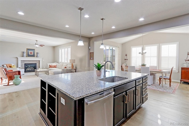 kitchen featuring dishwasher, a kitchen island with sink, sink, vaulted ceiling, and pendant lighting