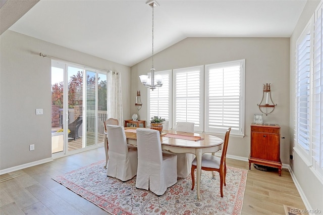 dining area with vaulted ceiling, light hardwood / wood-style flooring, plenty of natural light, and an inviting chandelier