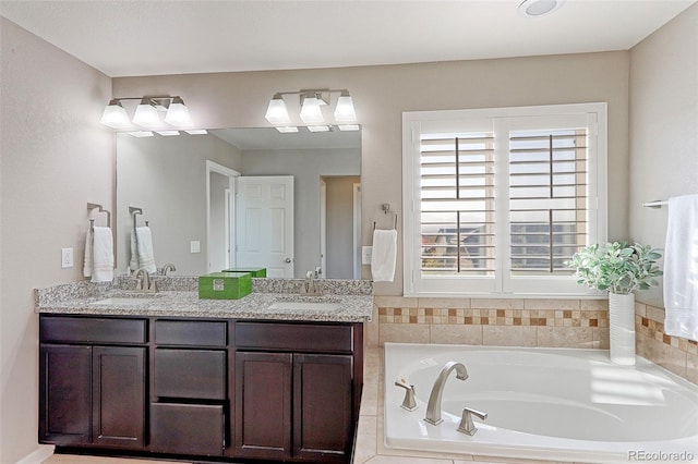 bathroom featuring vanity and tiled tub