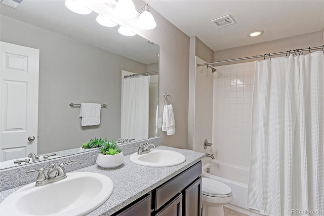 full bathroom featuring toilet, shower / bath combo with shower curtain, and vanity