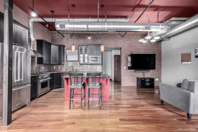 210 W Magnolia St Unit 360, Fort Collins, CO 80521 - kitchen with appliances with stainless steel finishes, light wood finished floors, open floor plan, and wall chimney range hood