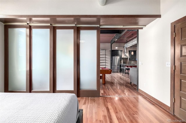 210 W Magnolia St Unit 360, Fort Collins, CO 80521 - bedroom featuring stainless steel refrigerator, light wood-style floors, and baseboards