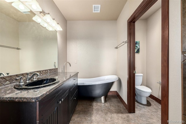 210 W Magnolia St Unit 360, Fort Collins, CO 80521 - bathroom featuring vanity, a freestanding bath, toilet, baseboards, and tile patterned floors
