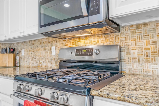 5320 E 100th Dr, Thornton, CO 80229 - kitchen featuring appliances with stainless steel finishes, backsplash, white cabinetry, and light stone countertops
