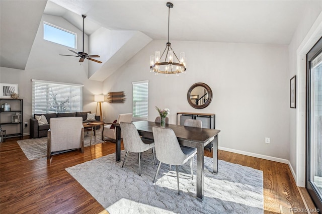 dining space with a wealth of natural light, baseboards, wood finished floors, and ceiling fan with notable chandelier