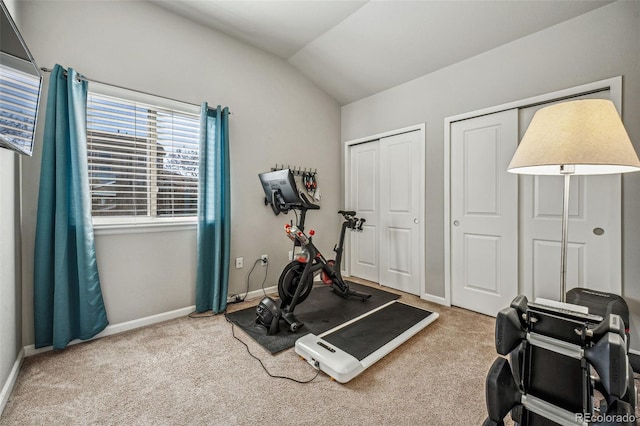 exercise area with lofted ceiling, carpet flooring, and baseboards