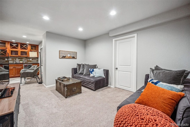 living area featuring baseboards, a dry bar, recessed lighting, and light colored carpet