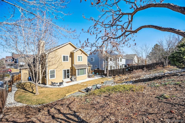 back of house featuring a residential view, a fenced backyard, and a patio