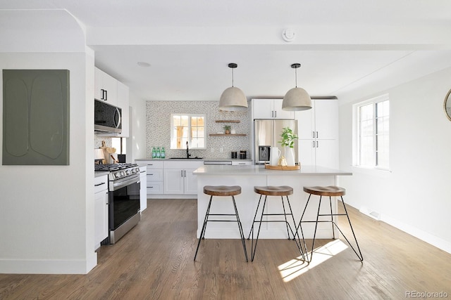 kitchen with a kitchen island, white cabinets, light countertops, appliances with stainless steel finishes, and open shelves