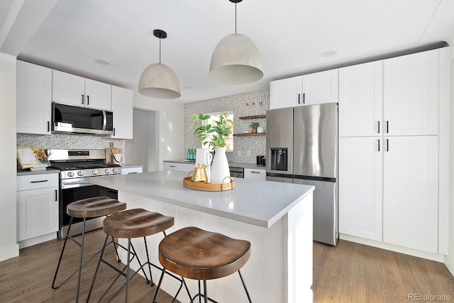 kitchen with stainless steel appliances, a center island, open shelves, light wood finished floors, and tasteful backsplash