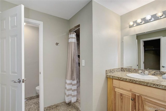 bathroom featuring vanity, toilet, and curtained shower