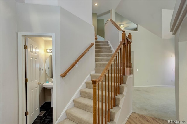 stairs with carpet floors and high vaulted ceiling