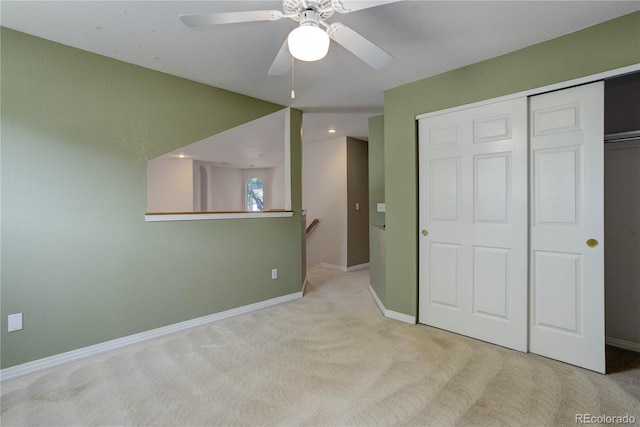 unfurnished bedroom with ceiling fan, light colored carpet, and a closet