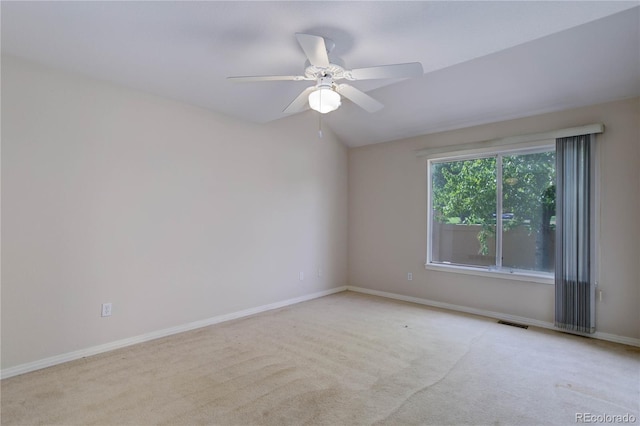 empty room featuring ceiling fan, light colored carpet, and lofted ceiling