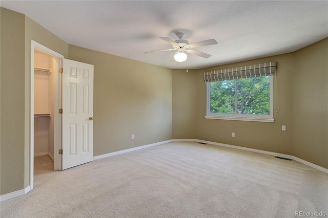 unfurnished room featuring light carpet, ceiling fan, and a textured ceiling