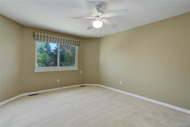 empty room with ceiling fan and light colored carpet