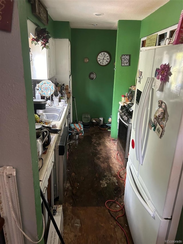 kitchen with white refrigerator, stainless steel gas range oven, and sink