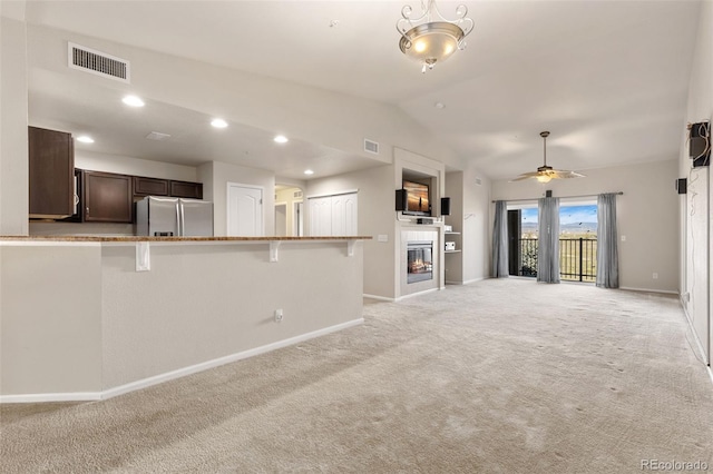 2405 Calais Dr Unit 18A, Longmont, CO 80504 - unfurnished living room featuring light carpet, baseboards, vaulted ceiling, a fireplace, and ceiling fan