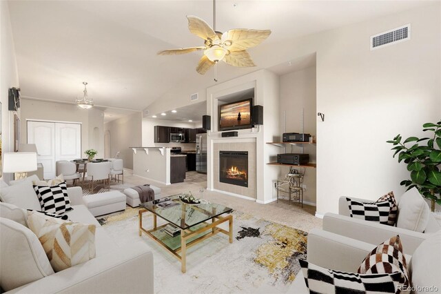 2405 Calais Dr Unit 18A, Longmont, CO 80504 - living area with lofted ceiling, ceiling fan, a tile fireplace, and baseboards