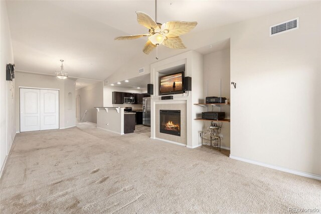 2405 Calais Dr Unit 18A, Longmont, CO 80504 - unfurnished living room featuring light carpet, lofted ceiling, baseboards, a ceiling fan, and a tile fireplace