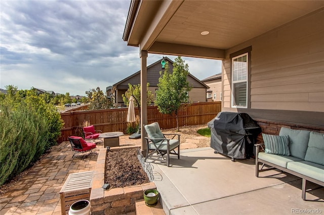 view of patio with an outdoor fire pit, area for grilling, and a fenced backyard