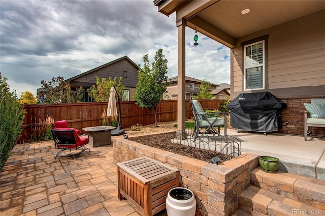 view of patio / terrace featuring fence, a fire pit, and area for grilling