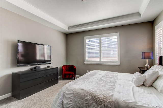 carpeted bedroom featuring baseboards, a raised ceiling, and crown molding