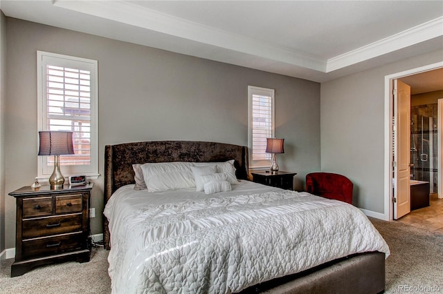 carpeted bedroom featuring a tray ceiling and baseboards