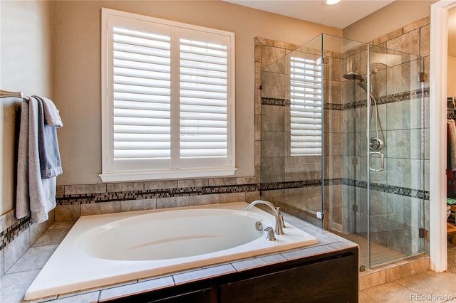 full bath featuring a stall shower, a garden tub, and tile patterned floors