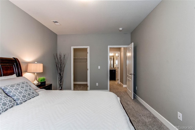 bedroom with baseboards, visible vents, carpet, a spacious closet, and a closet